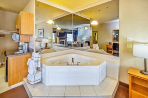 A modern bathroom with a large bathtub, a vanity with a sink, and a mirror.