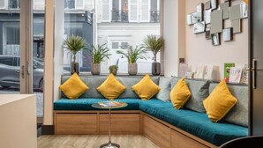 A modern interior with a built-in bench seating area, potted plants, and a wall-mounted mirror display.
