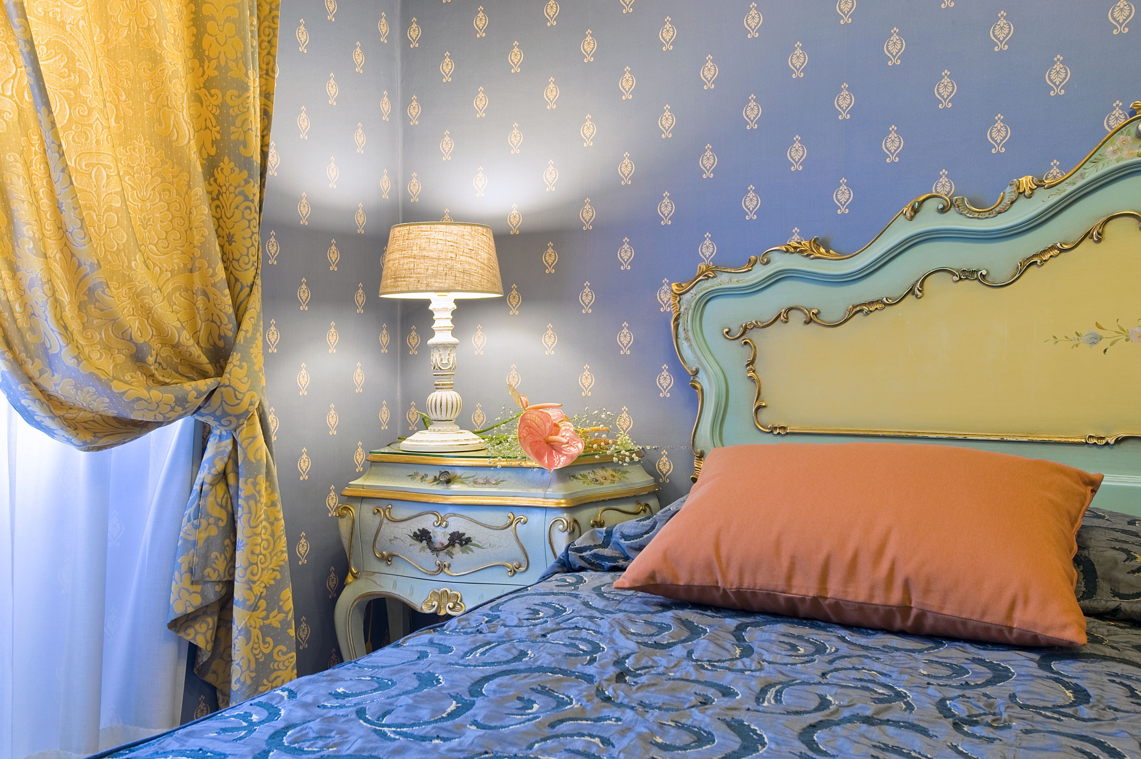 Una camera da letto con un letto, un comodino, una lampada e un oggetto decorativo.