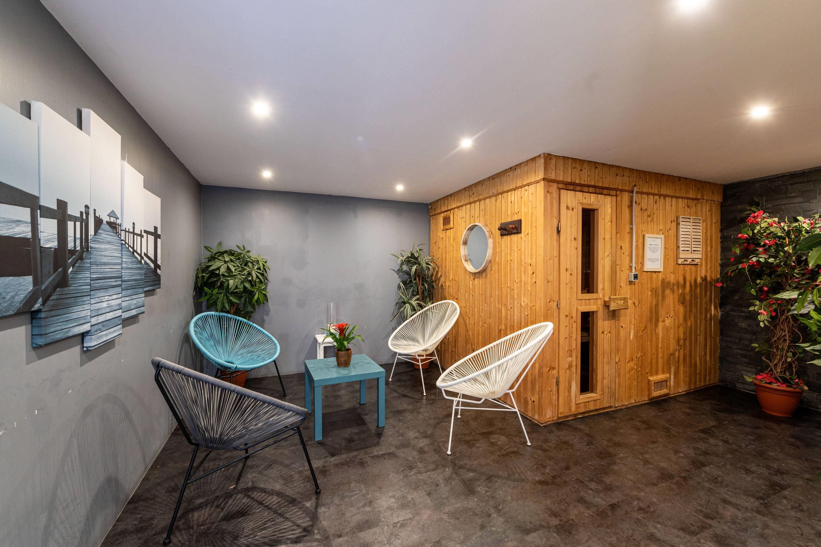 A modern interior with a wooden partition, white wire chairs, a small table with a potted plant, and a wall-mounted mirror.