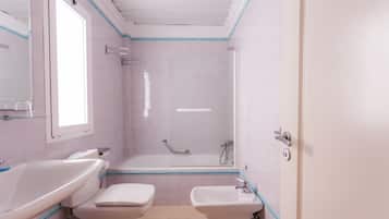 Un baño con inodoro, lavamanos y bañera.