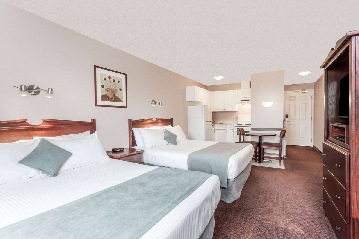 Efficiency, Room, 2 Queen Bed, Non Smoking | โต๊ะทำงาน, พื้นที่ทำงานแบบใช้แล็ปท็อป, ผ้าม่านกันแสง, เตารีด/ โต๊ะรีดผ้า
