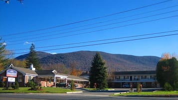 A motel with a sign reading "Homer Jackson" in front of a mountain backdrop.