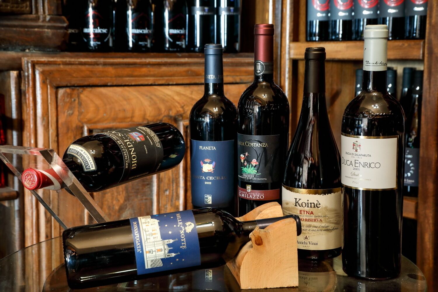 Varias botellas de vino sobre una barra con un fondo de madera.