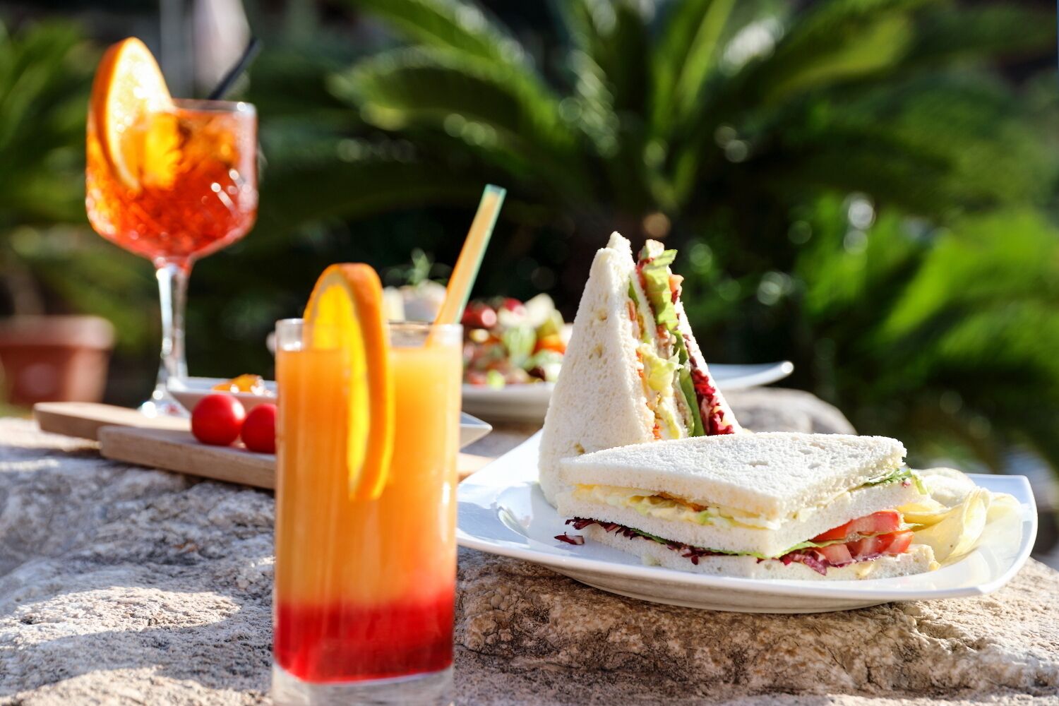 A table with a sandwich and a glass of juice.
