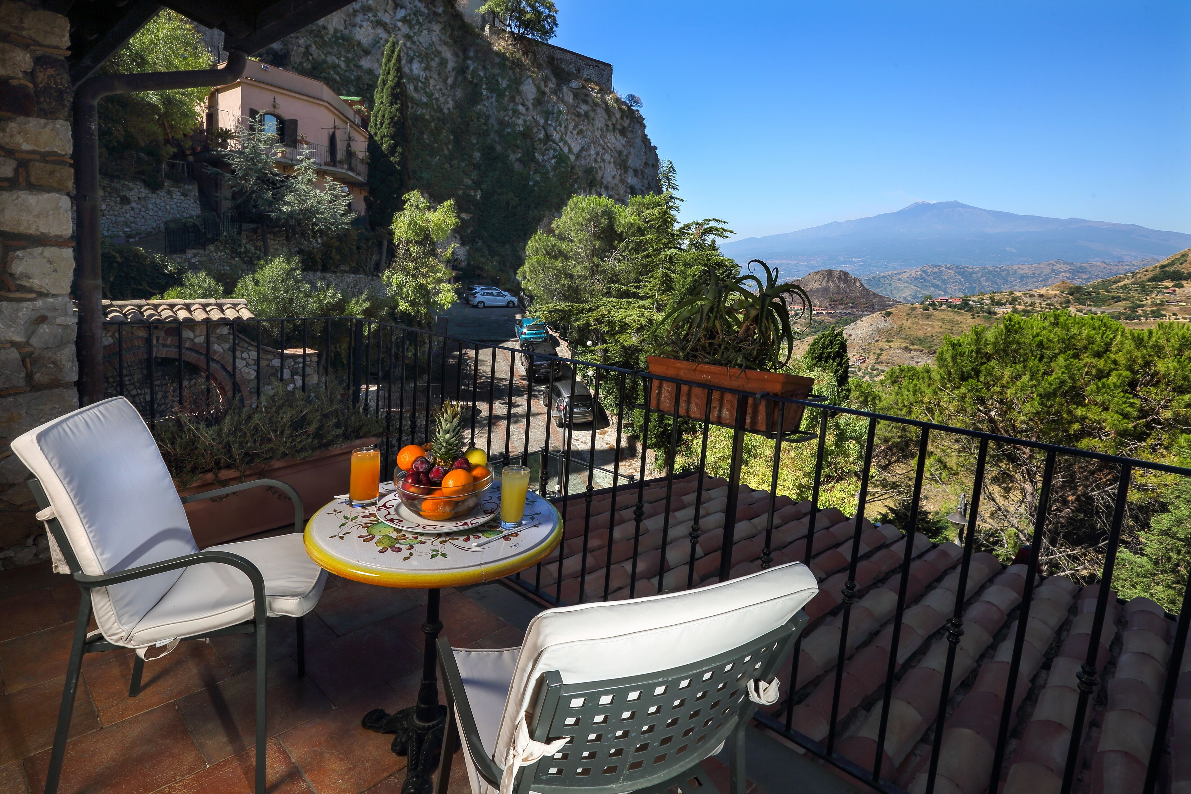Eine Terrasse mit Tisch für zwei Personen mit Blick auf eine Berglandschaft.