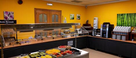 A buffet area with various food items and a coffee station.