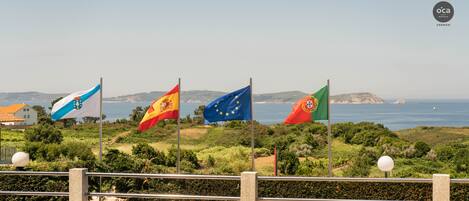 Vista costera con las banderas de España, Portugal y la Unión Europea.