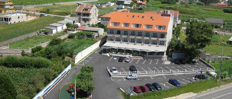 Un hotel con estacionamiento, parque infantil y vistas del paisaje circundante.