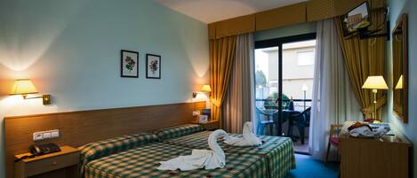 A hotel room with two beds, a desk, a chair, a telephone, and a window with curtains.