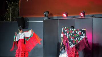 Un escenario con dos artistas vestidos con traje tradicional.