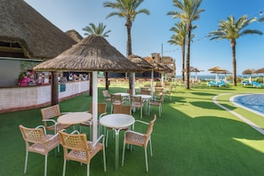 A resort with outdoor seating, a bar, and a pool area.