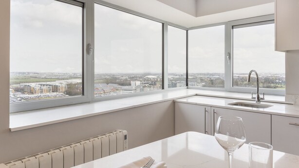 Una cocina moderna con ventanas amplias, un lavaplatos empotrado y vistas a la ciudad.