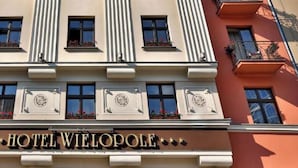 A hotel facade with a classic architectural style, featuring a prominent entrance with a clock and the name "HOTEL WIELOPOLE". - Hotel Wielopole (Kraków)