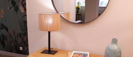 Un bureau en bois, une lampe, un vase et un livre.