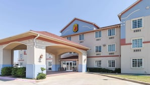 A hotel with a prominent 'Speed 8' logo, a covered entrance, and a large parking lot. - Super 8 by Wyndham Alvarado (Alvarado)