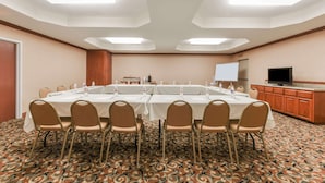 A conference room with a long table, chairs, and a television on a cabinet. - Super 8 by Wyndham Alvarado (Alvarado)
