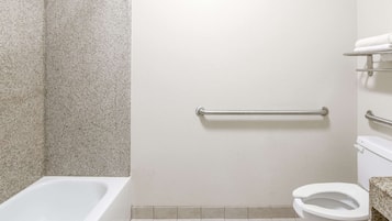 A bathroom with a bathtub, toilet, and grab bar.