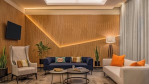 Una sala de estar moderna con un sofá, sillones y una mesa de centro.