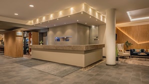 Zona de recepción con mostrador, asientos y diseño moderno.