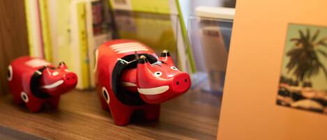 A shelf with books and a piggy bank.
