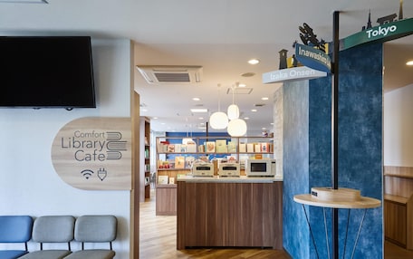 A library cafe with seating, a counter with food items, and a sign indicating Tokyo.