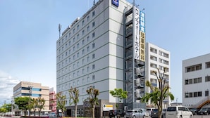 Un hotel de varios pisos con un llamativo letrero Comfort Inn, un garaje de estacionamiento y un cielo despejado.
