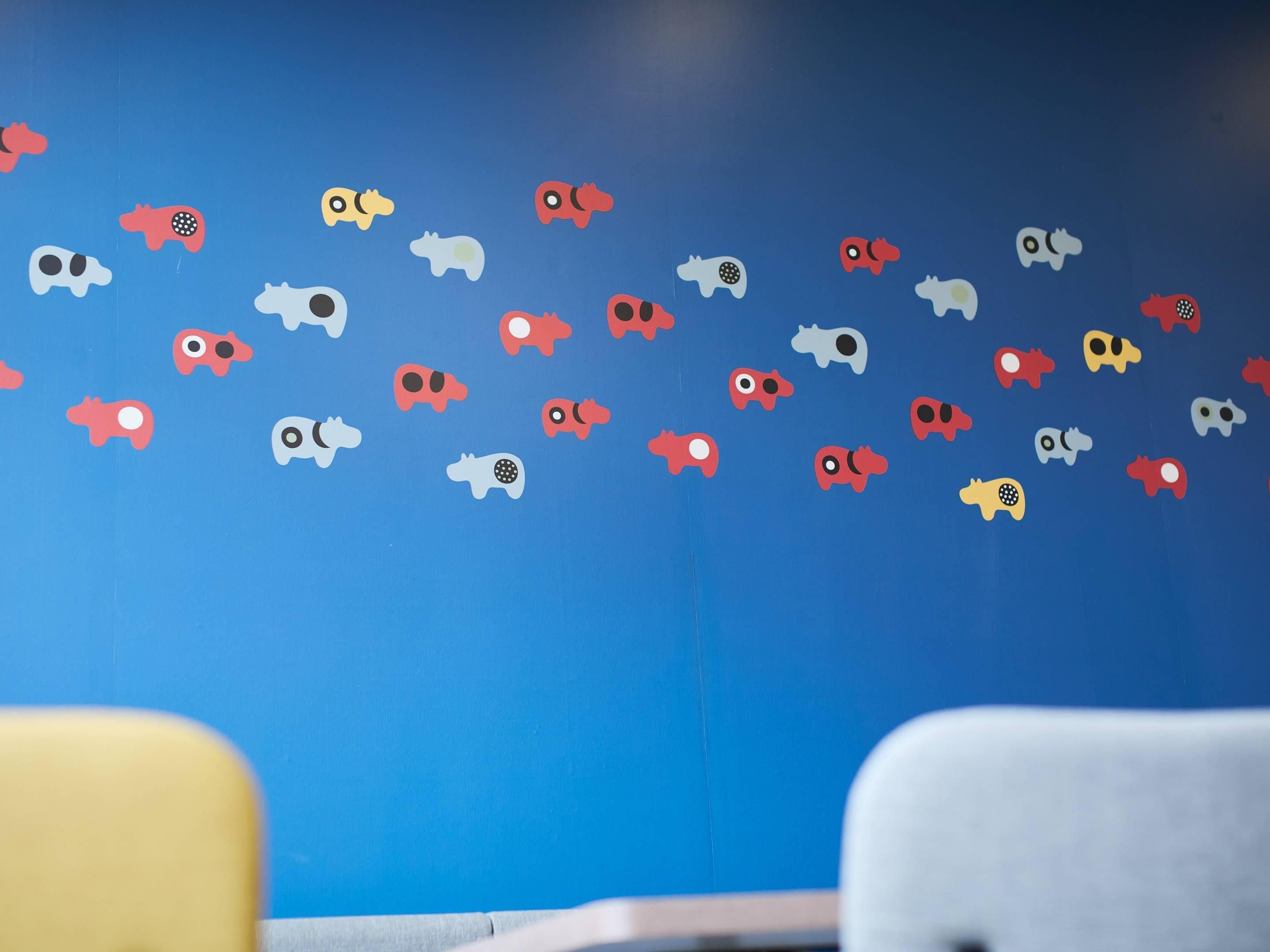 Une pièce dont un mur bleu est décoré d’autocollants représentant des animaux aux couleurs vives.