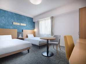 Une chambre d’hôtel avec deux lits, une table ronde, une chaise, une armoire et une fenêtre avec des rideaux.