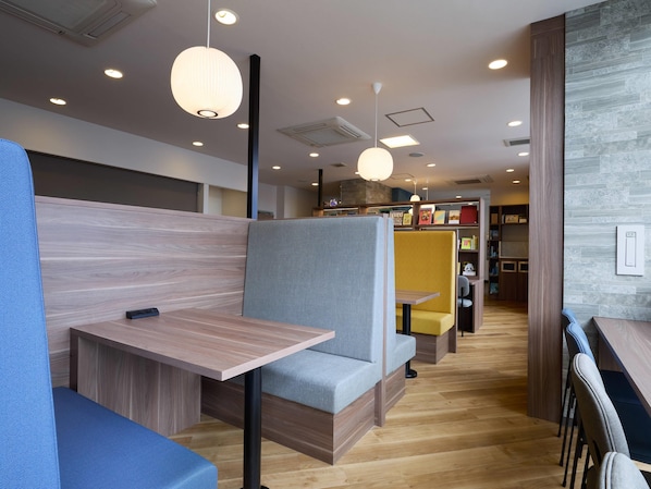 A modern interior with seating areas, wooden flooring, and pendant lighting. - Comfort Hotel Koriyama (Koriyama)
