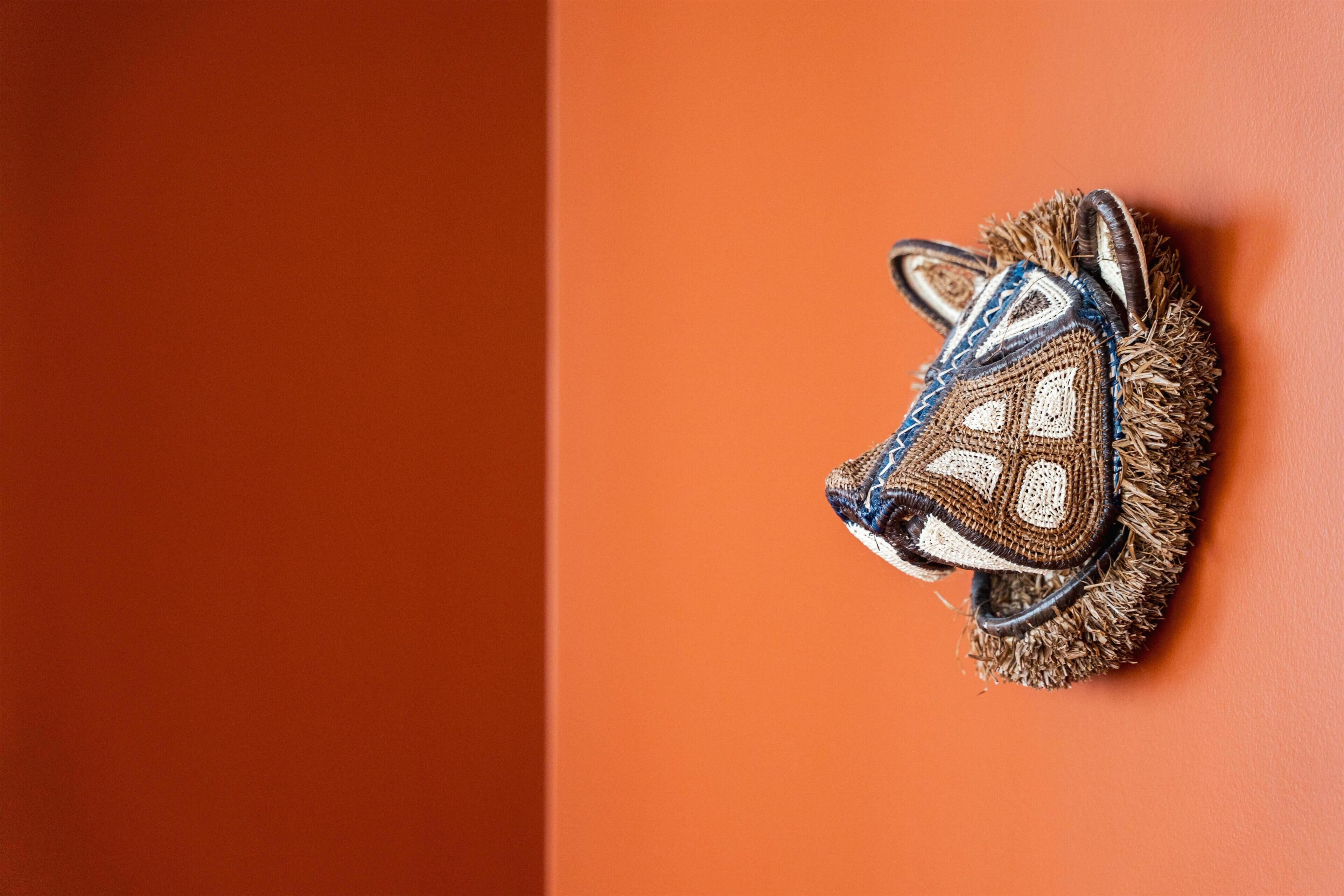 A wall-mounted decorative item resembling a fox head with intricate patterns.