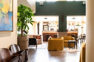 Amplia sala de estar con asientos, un bar y una planta grande en maceta.
