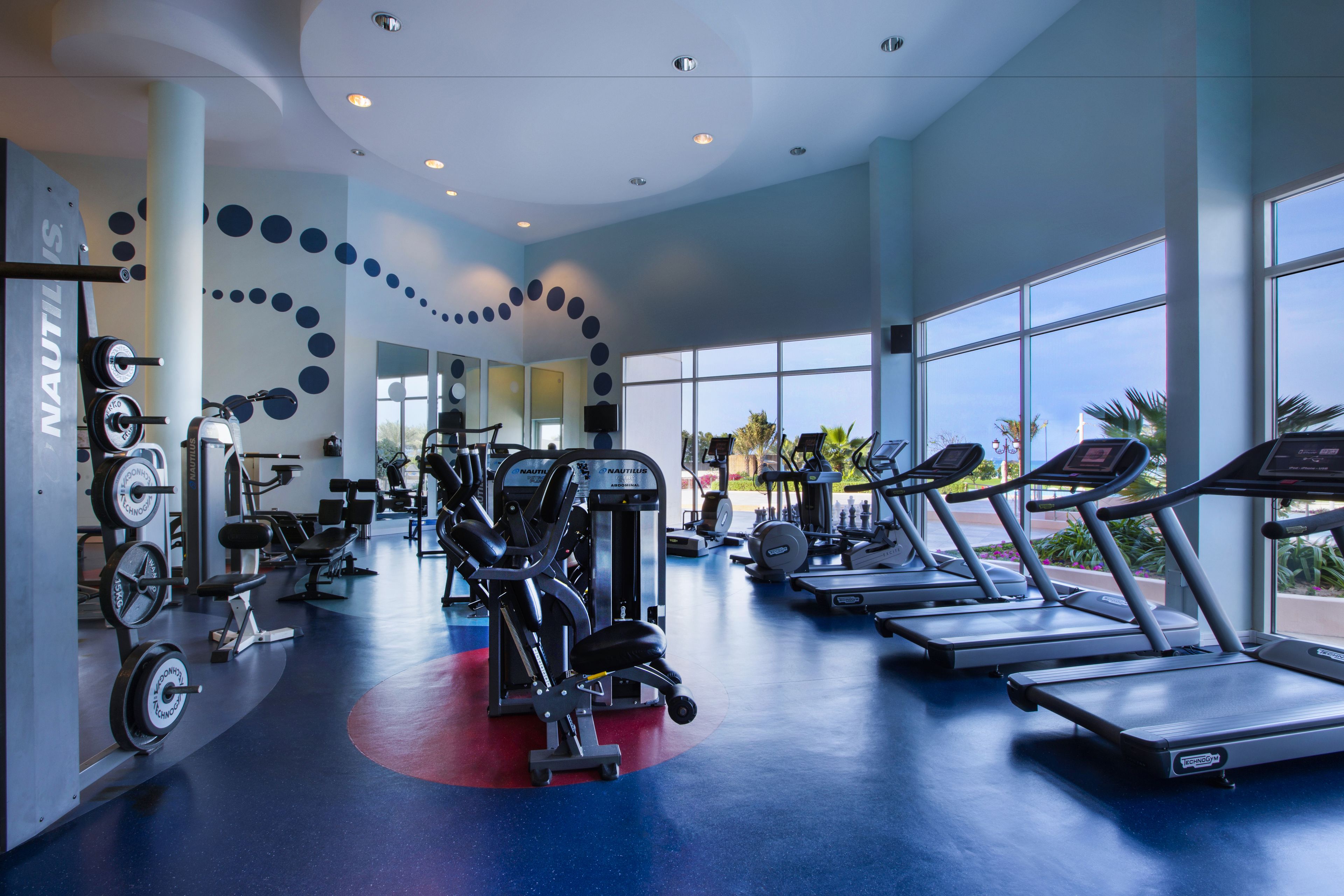 Een moderne sportschool met loopbanden, krachttoestellen en gewichten.