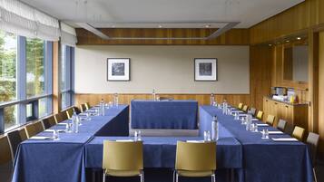 A conference room with a long table, chairs, and framed pictures on the wall.