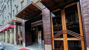 A hotel entrance with a red carpet, large wooden doors, and a staircase leading to the entrance. - Metropolo Classiq Shanghai Nanjing Road East Hotel (Shanghai)