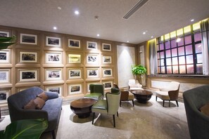 A lobby with framed pictures on the wall, a potted plant, and modern seating. - Metropolo Classiq Shanghai Nanjing Road East Hotel (Shanghai)