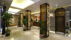 A spacious lobby with a polished floor, large potted plants, and a reception desk. - Metropolo Classiq Shanghai Nanjing Road East Hotel (Shanghai)