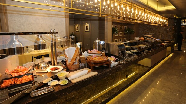 A buffet setup with various food items and kitchen equipment. - Metropolo Classiq Shanghai Nanjing Road East Hotel (Shanghai)