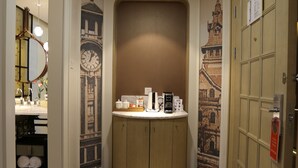 A hotel lobby with a reception desk, a large wall clock, and a patterned floor design. - Metropolo Classiq Shanghai Nanjing Road East Hotel (Shanghai)