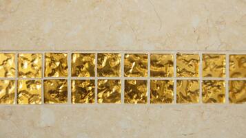A tiled wall with a gold-colored decorative border.