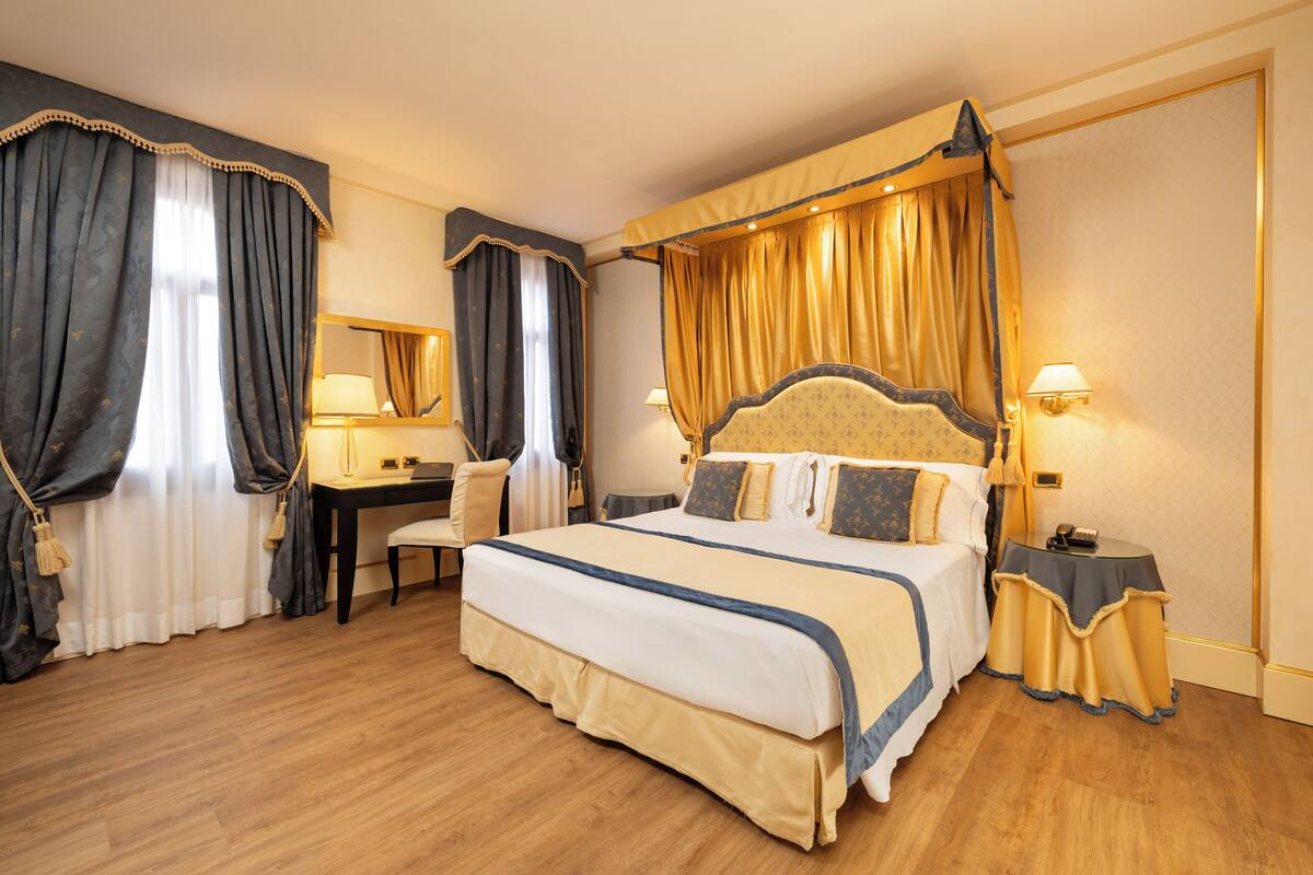 A spacious bedroom with a large bed, a desk, and a chair.