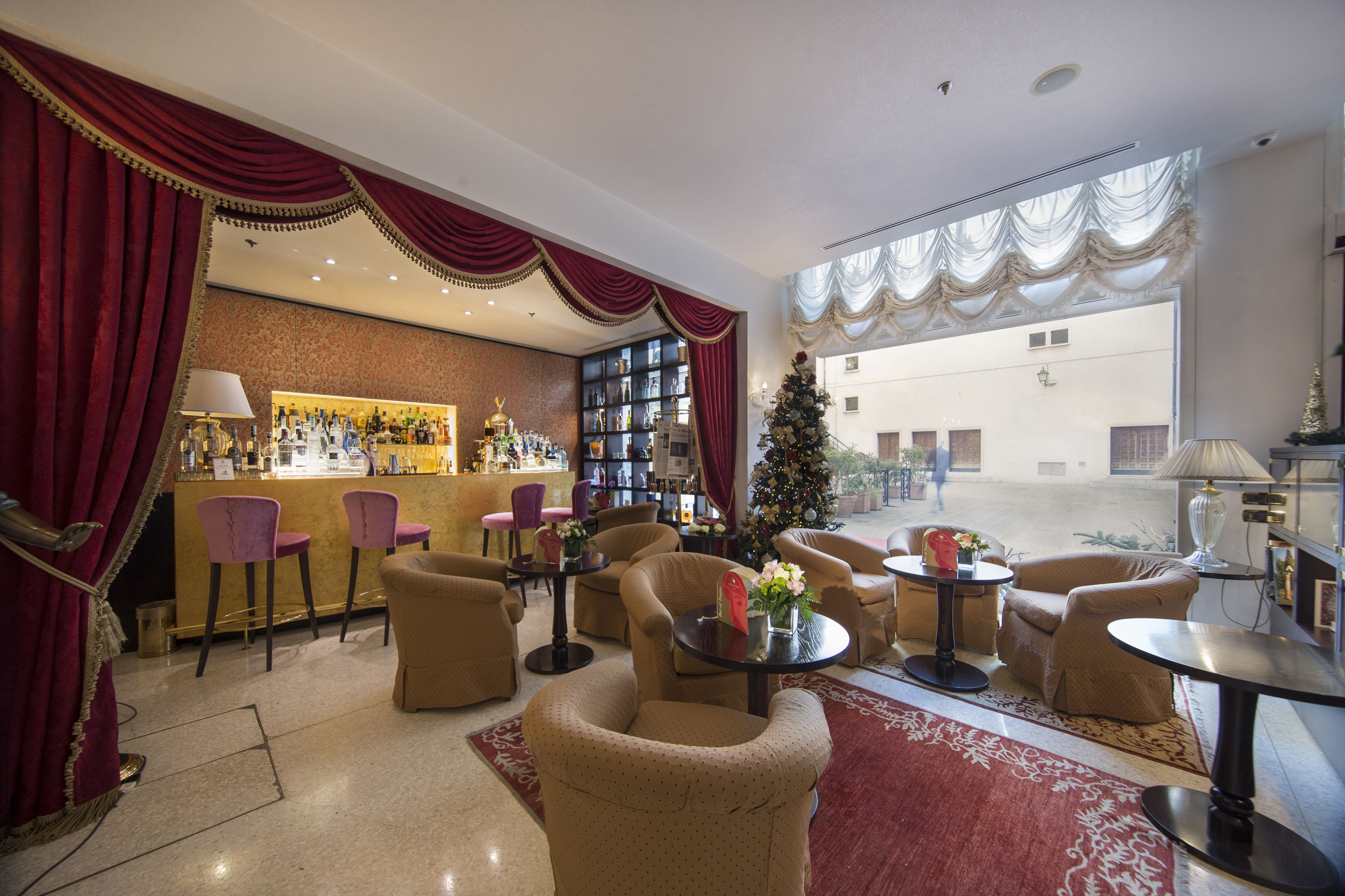 A hotel lobby with a bar area, seating arrangements, and a Christmas tree.