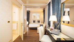 A hotel room with a bed, a desk with a laptop, a chair, a mirror, and a shower area. - Hotel A LA Commedia (Venice)