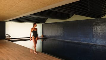 Una piscina cubierta, tumbonas