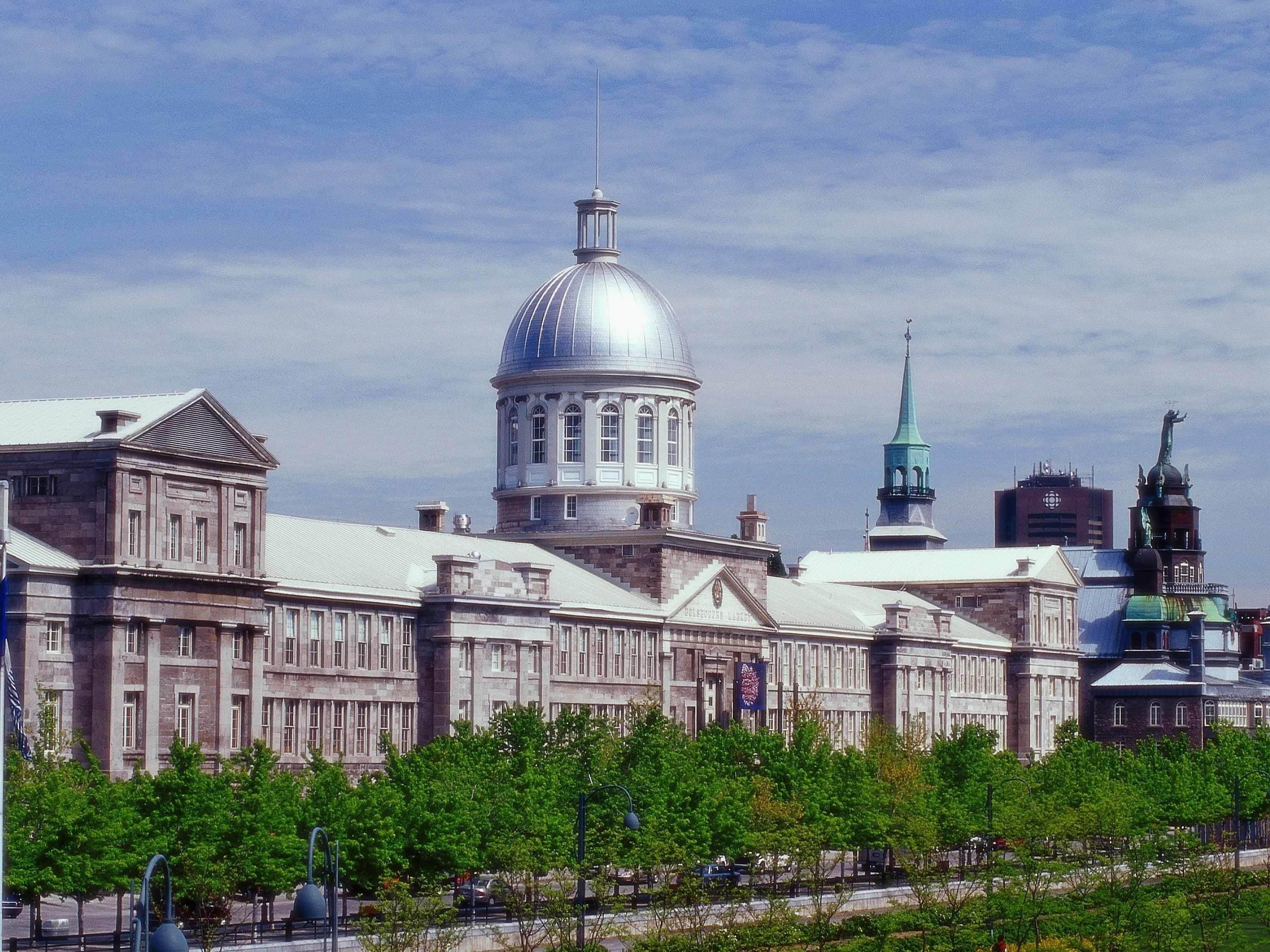 Un edificio grande con una cúpula destacada, una aguja y una estatua.
