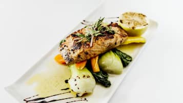 A plated dish with grilled chicken, vegetables, and a sauce.