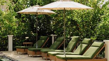 A poolside area with lounge chairs and umbrellas.