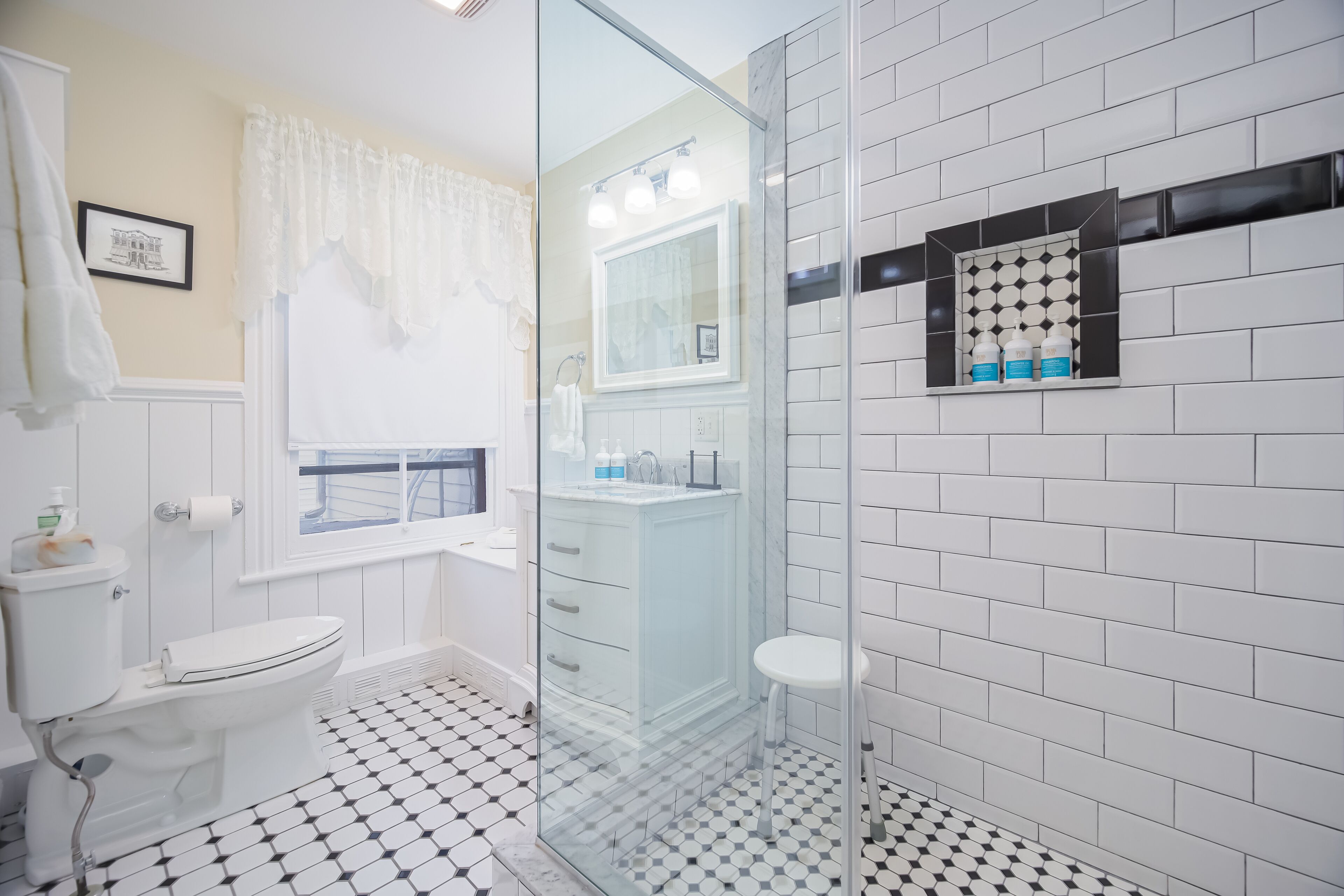 Une salle de bain comprenant des toilettes, un lavabo et une douche à parois de verre.