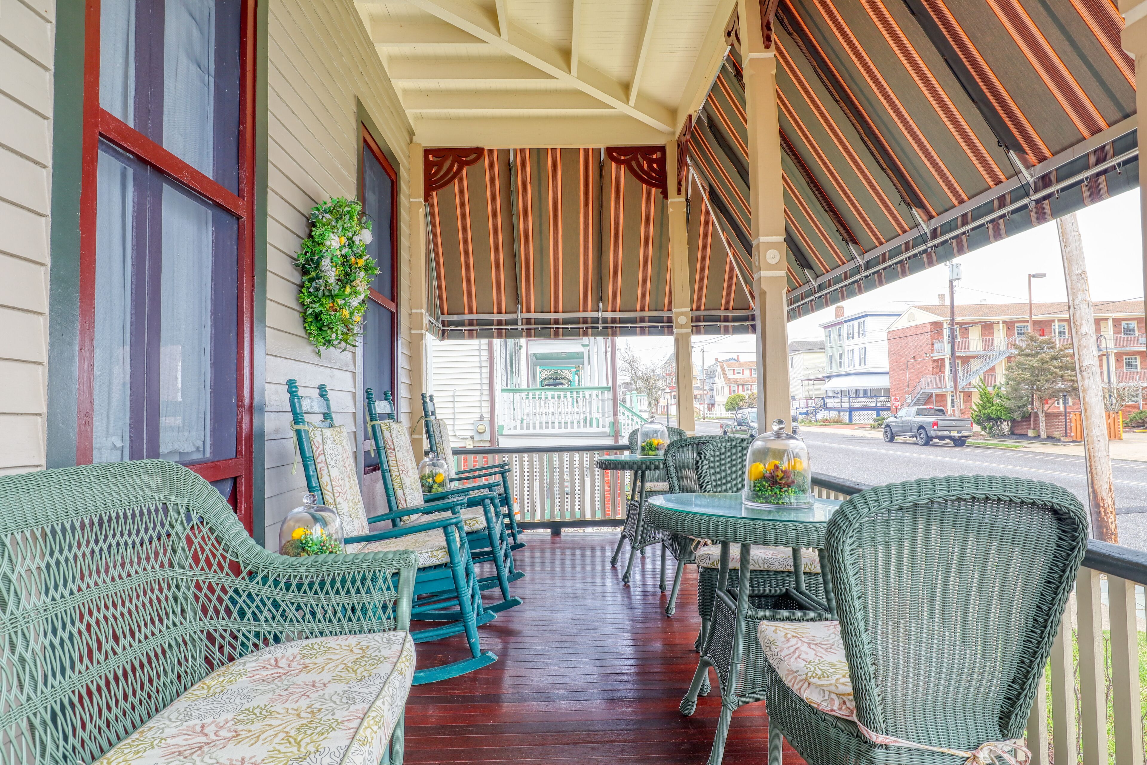 A covered porch with wicker furniture and a view of the street.
