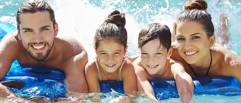 Una piscina al aire libre, sombrillas, sillones reclinables de piscina